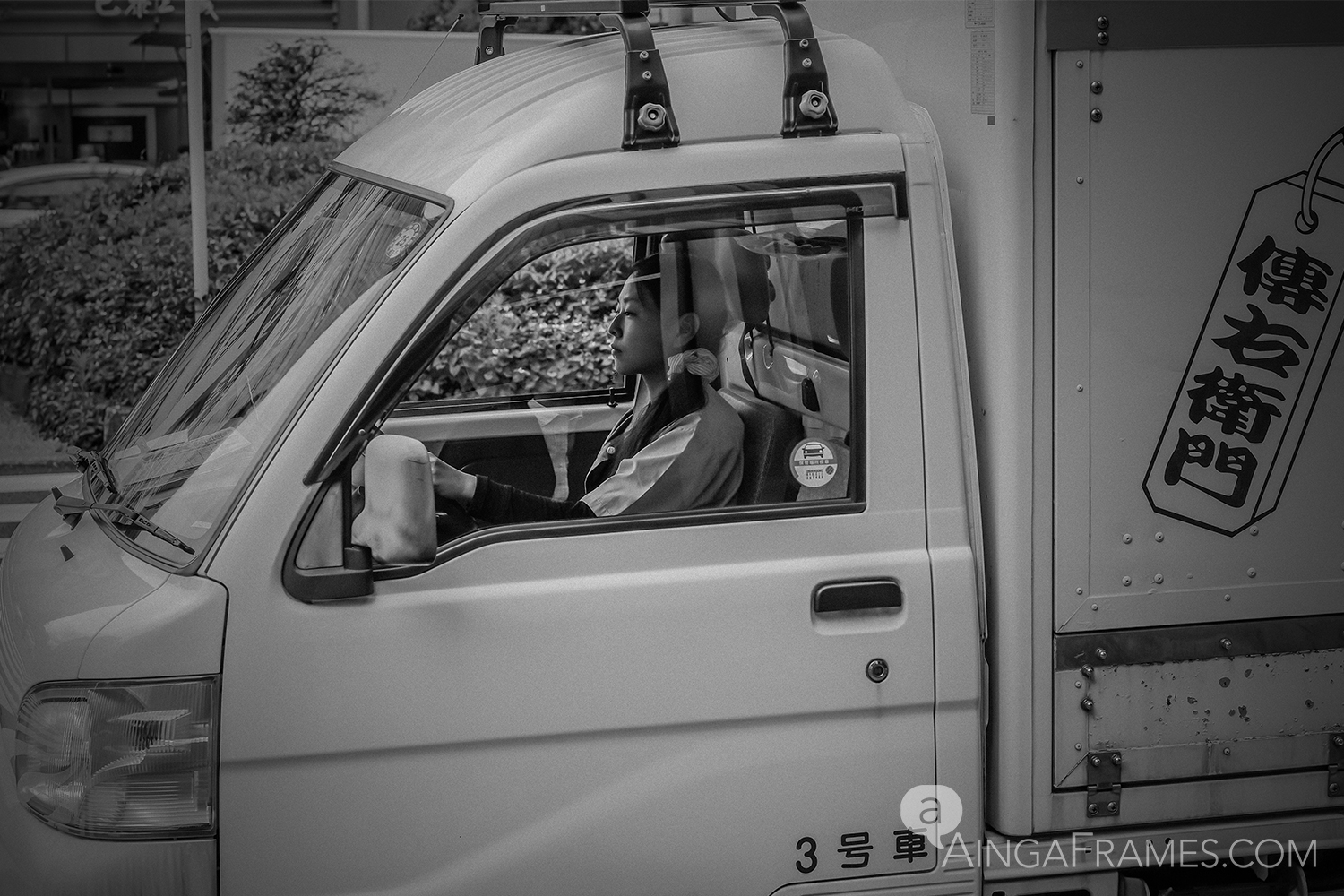 The expressionless face of the young female truck driver making her early morning run near Tsukiji, Tokyo.