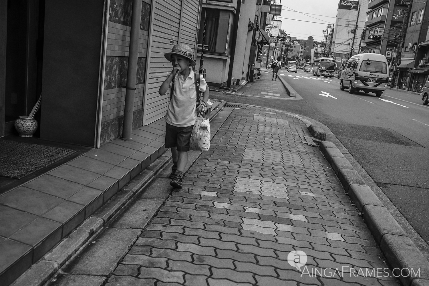 Chewing on an ice-cold popsicle he just bought at a convenient store, an elementary school student hurries his way home.